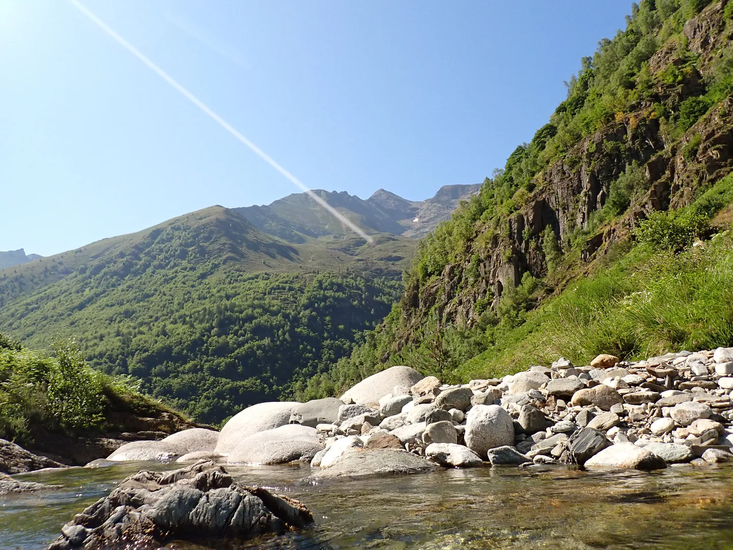Paysage ariègeois lors d'une sortie outdoor avec une montagne verdoyante, une rivière sur fond de massif du Montcalm